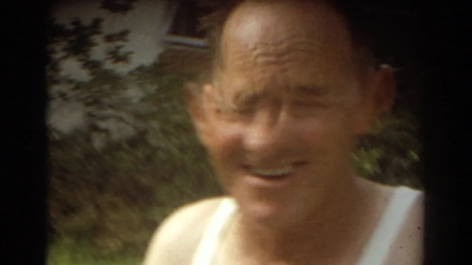 Close-up 1967 Fort Lauderdale home-movie frame of a smiling adult man in a white tank top outdoors.