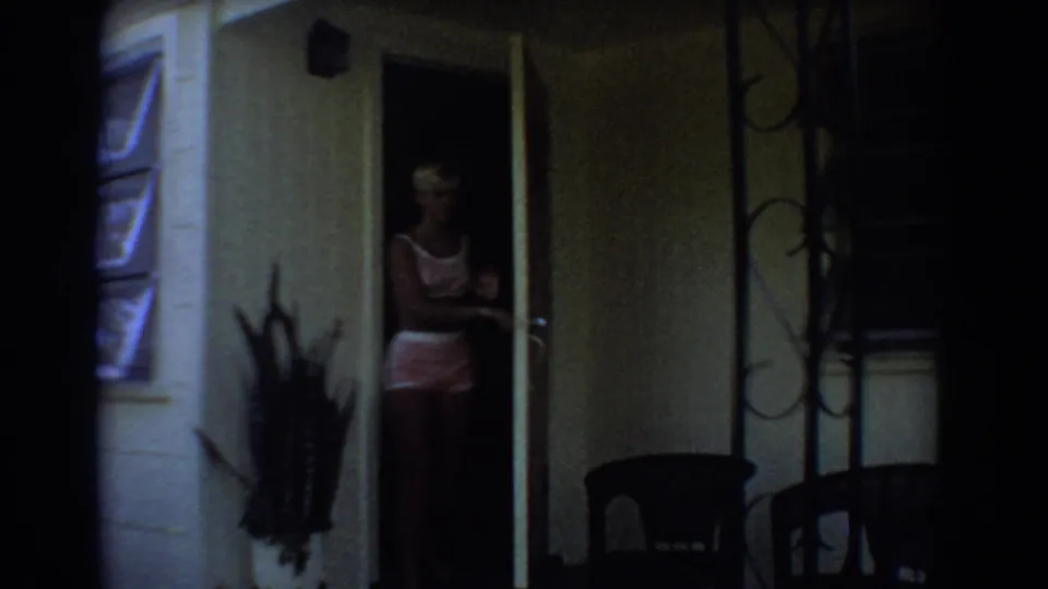 A blonde woman in a light top and shorts appears in the shaded doorway of a Fort Lauderdale residence.