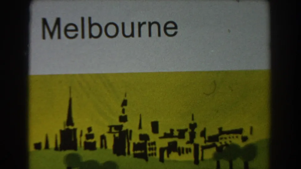 1967 Melbourne travel title card with large lettering and a silhouetted city skyline graphic on yellow-green 8mm film.