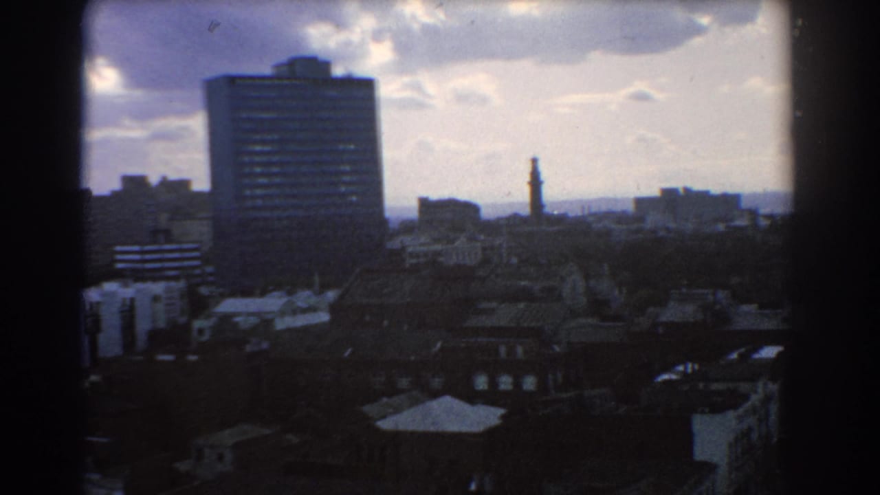 Elevated view of Melbourne buildings under a cloudy blue sky.