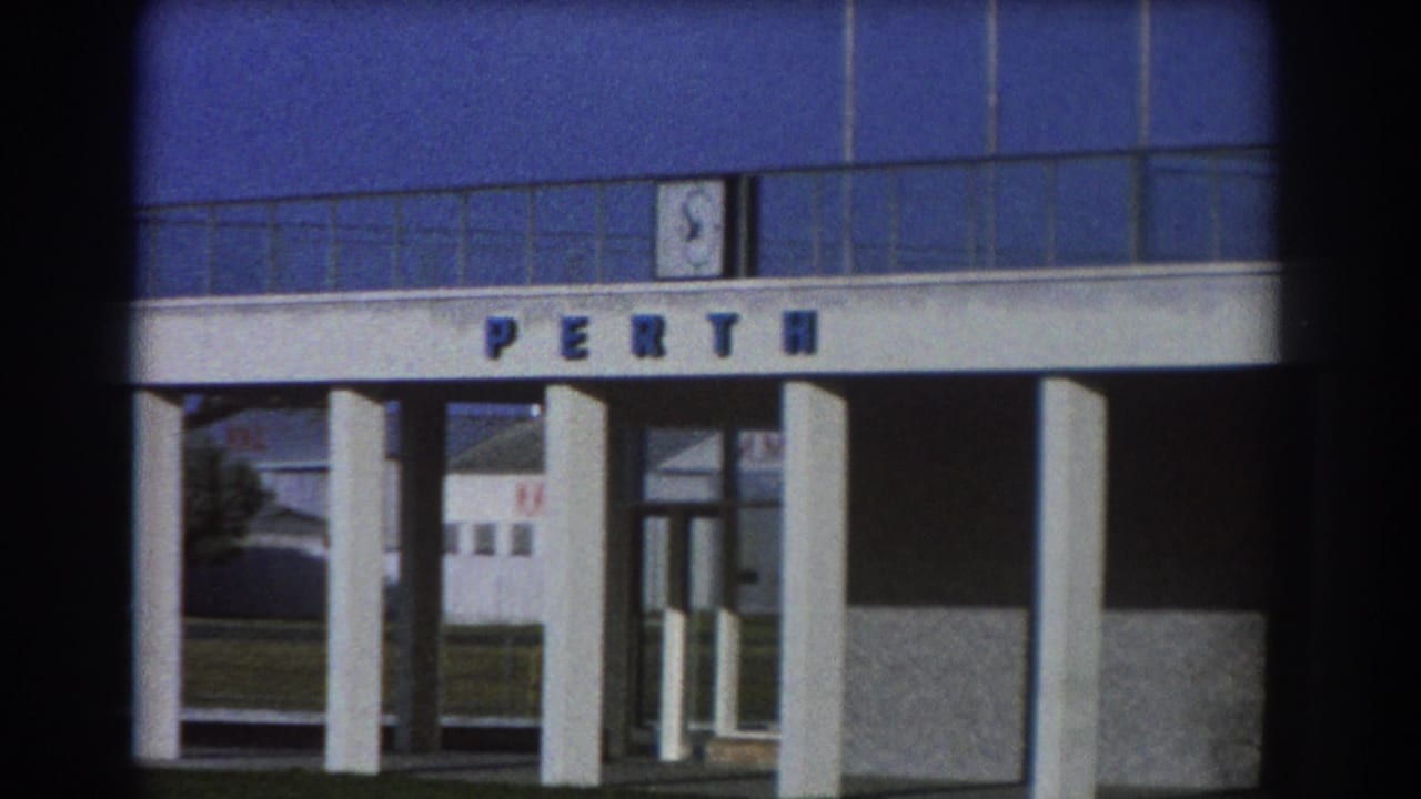 Modern entrance facade with PERTH letters above columns and glass doors.