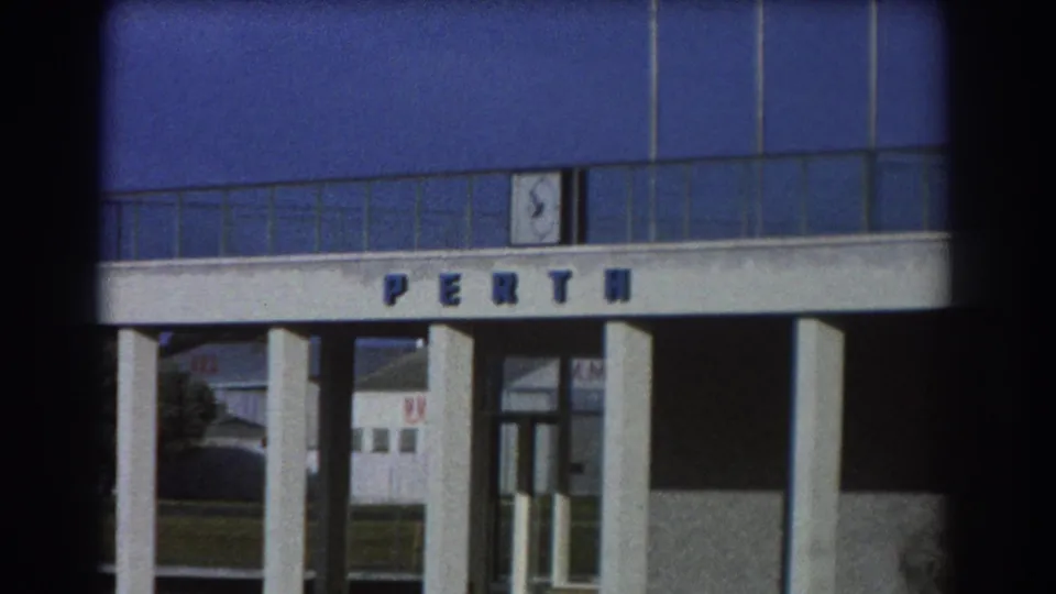 1967 Perth footage frames the PERTH entrance more closely, showing the colonnade, glass doorway, and blue upper facade.