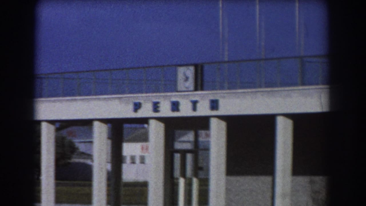 Perth terminal facade with large lettering and columns seen through dark film edges.