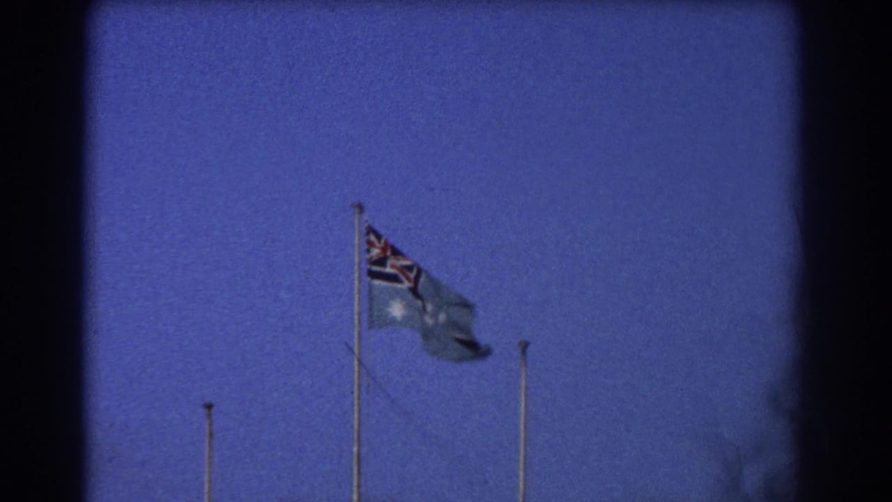 Australian flag on a tall pole against a deep blue sky with dark 8mm frame borders.