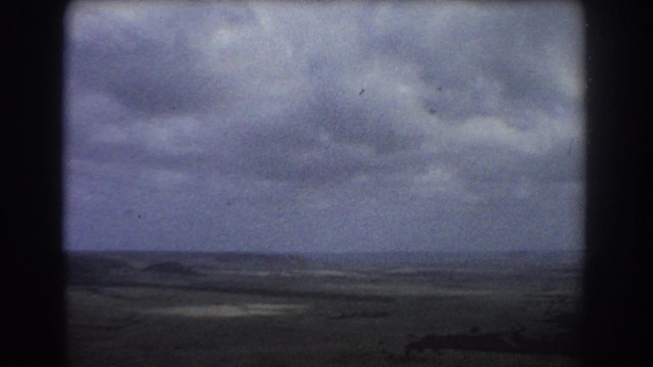 Overcast sky above a distant flat landscape and low hills.