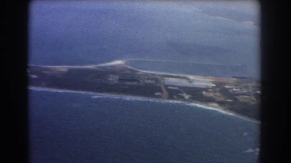 Soft 8mm aerial view over Perth coastal land and ocean, with a long beach edge and developed areas along the shore.