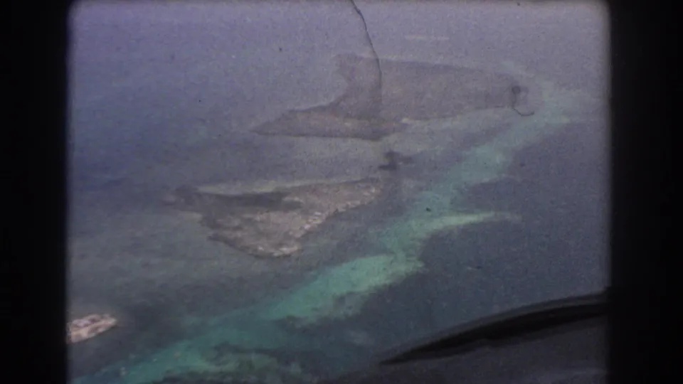 A 1967 home-movie aerial view near Perth, Australia, with small islands or sandbars divided by blue-green tidal water.
