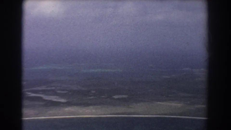 Faded 1967 8mm aerial view near Perth showing coast, waterways, ocean, and dark film-frame edge.