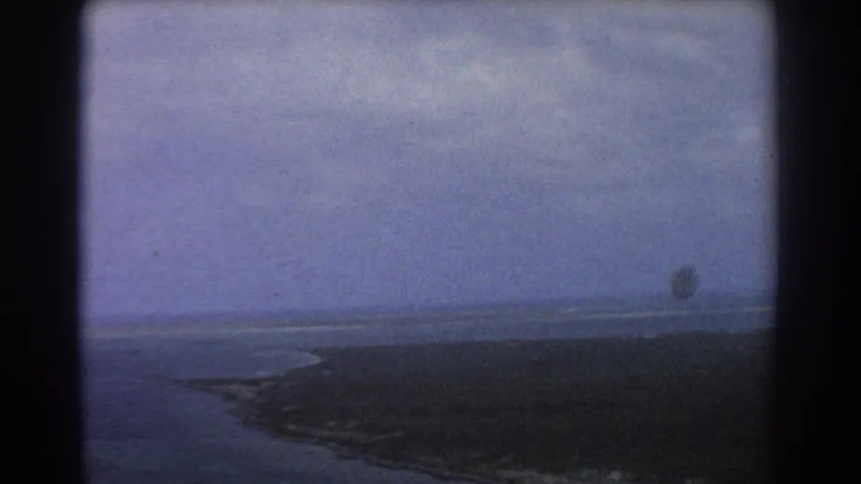 Aerial view near Perth in 1967 showing ocean, curved shore, low coastal land, and visible 8mm frame borders.