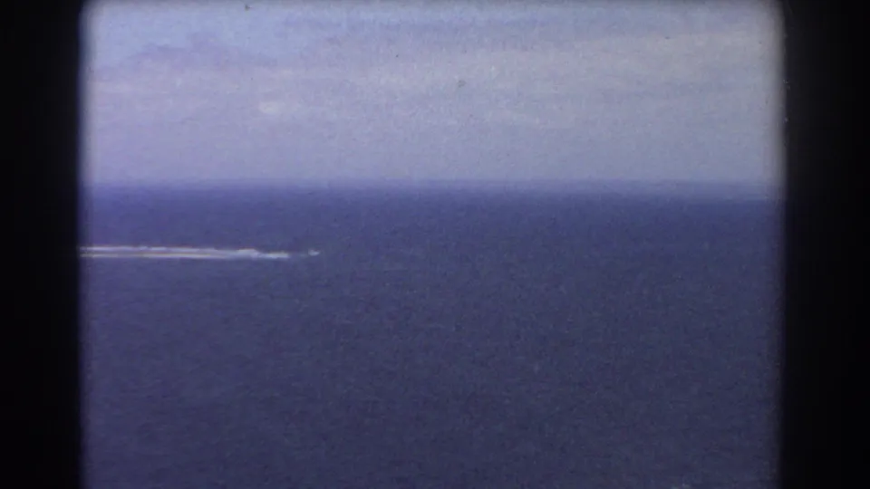 1967 Perth-area 8mm frame showing open blue ocean with a small distant white wake near the horizon.