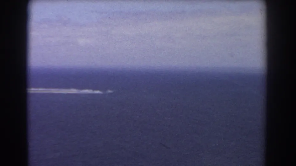 1967 8mm ocean frame from the Perth-area clip, showing a small distant wake against deep blue water.