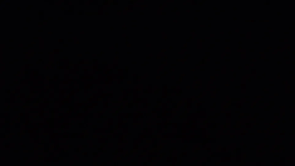 A near-black transitional frame from the 8mm clip, with little visible detail between aerial island views.