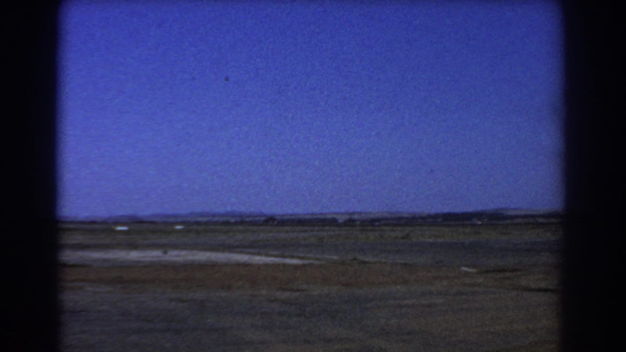 Open flat fields beneath a deep blue sky with a low horizon.