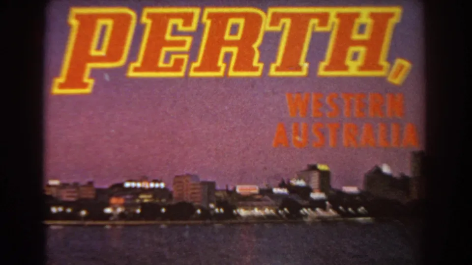 1967 8mm frame showing the Perth, Western Australia title card over a waterfront skyline and night-lit buildings.
