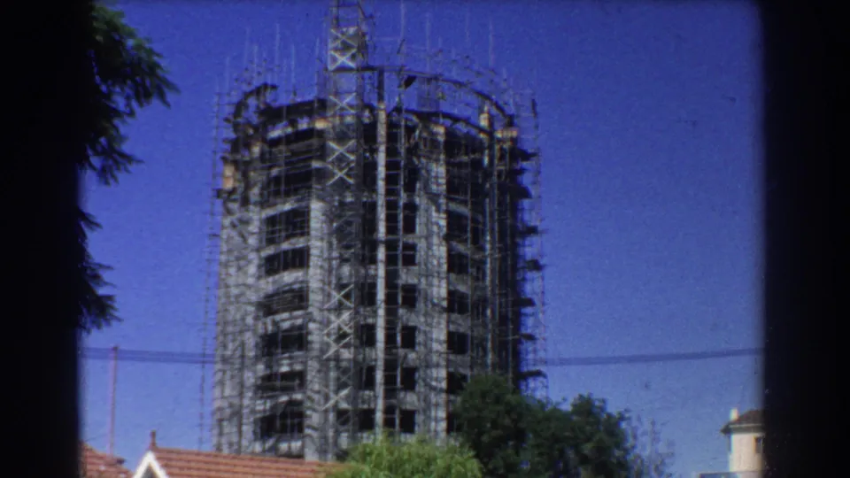 Perth 1967 frame of a round high-rise structure under construction, with scaffolding and mast structures visible.