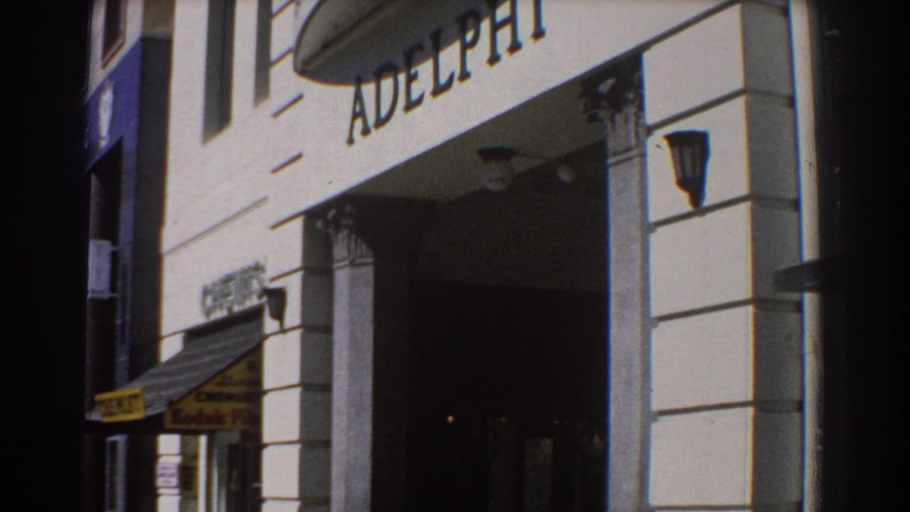 ADELPHI lettering above a building entrance with columns and an awning at street level.