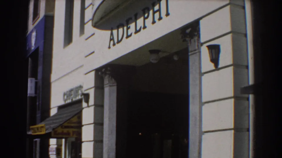 1967 Perth view of the ADELPHI facade, showing the entrance bay, wall lamps, column details, awning and visible Kodak Film signage.