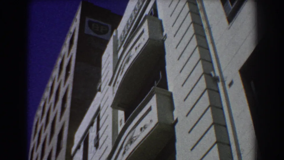 Low-angle 1967 Perth street view looking up at adjacent commercial buildings, including balconies, windows and a BP sign near the upper facade.