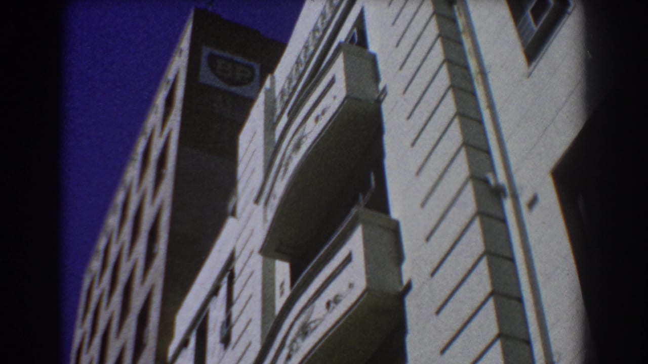 Low-angle view of sunlit multistory buildings with balconies and a BP sign.