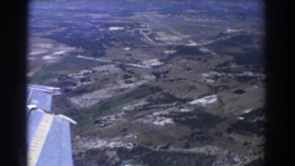 1967 airplane-window view near Perth showing a wing corner, patchwork fields, and rural roads below.