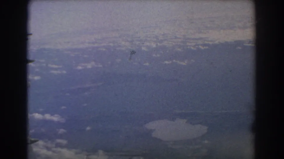 1967 8mm travel frame showing a hazy aerial view near Perth, Australia, seen from an airplane passenger perspective.