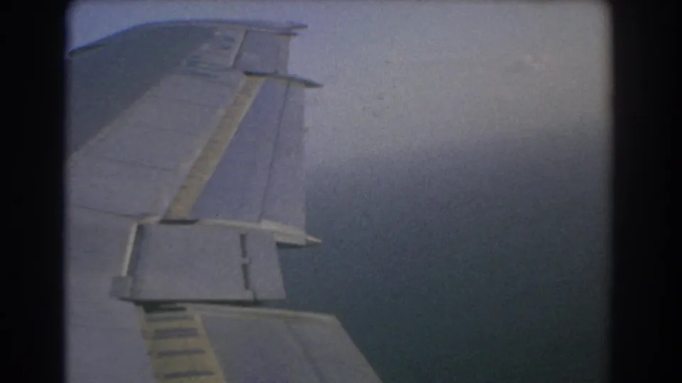 Final sampled frame of a 1967 Perth flight view, with the airplane wing set against darker blue-gray cloud bands.