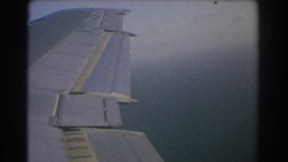 Passenger-seat view from an aircraft near Perth in 1967, with the wing over hazy sea below.