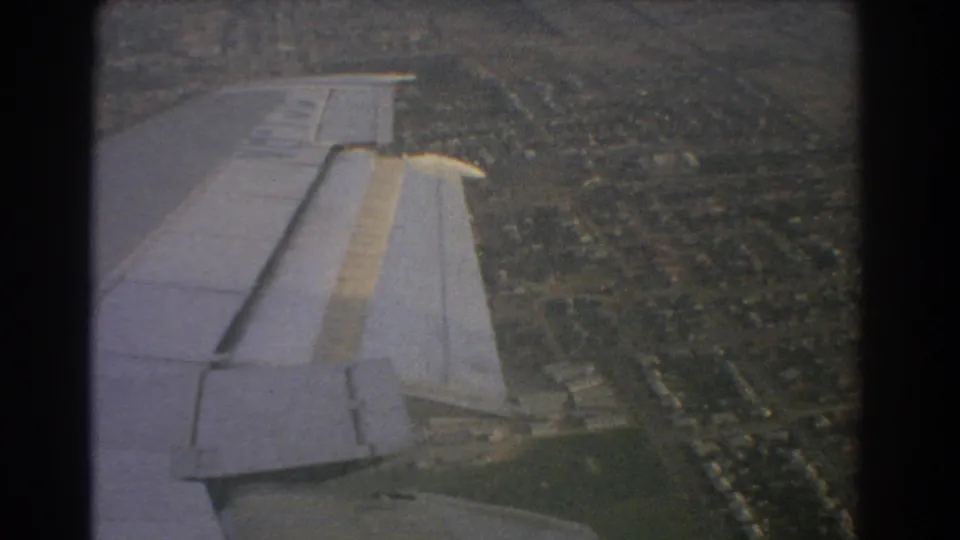 Perth, Australia home-movie frame from 1967 with the aircraft wing foregrounding suburbs and green open areas below.
