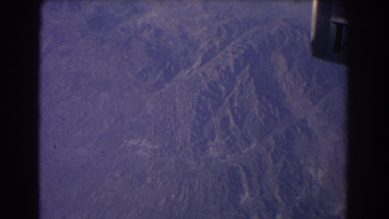 Purple-blue textured planetary surface framed by dark 8mm film borders.
