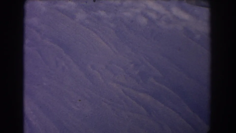 1967 8mm frame with a muted purple Earth-like surface, diagonal texture, black edge framing, and scattered dust marks.