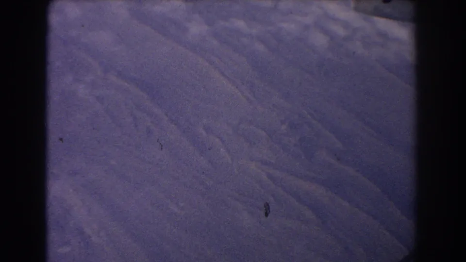 1967 8mm frame of a purple Earth-like or projected space view, with soft texture, black borders, dust, and a small vertical mark.