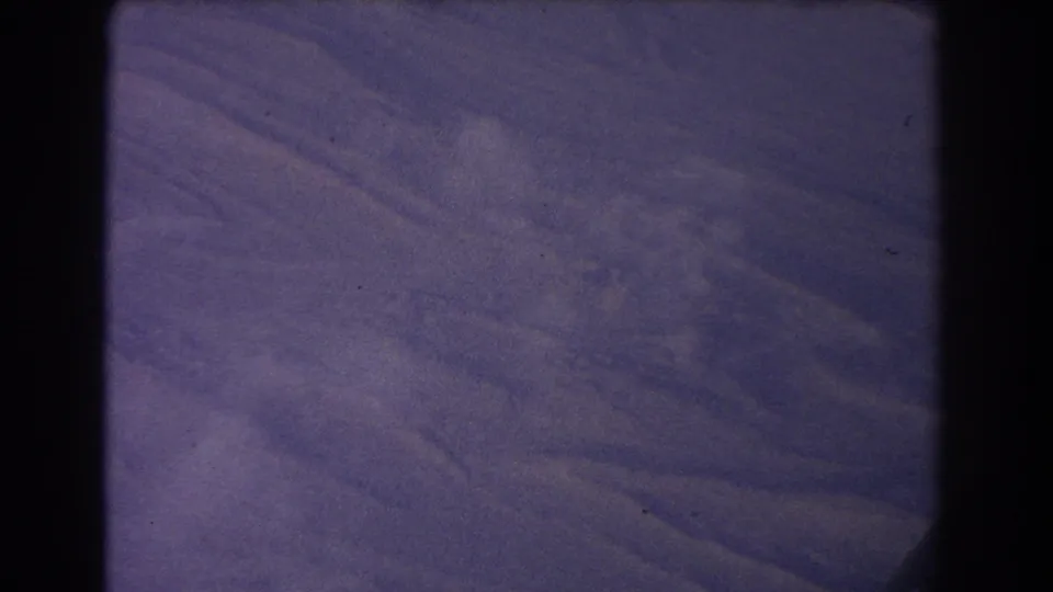 1967 8mm home-movie still showing layered mountain ridges near Sydney, Australia, with soft grain and dark film gate borders.
