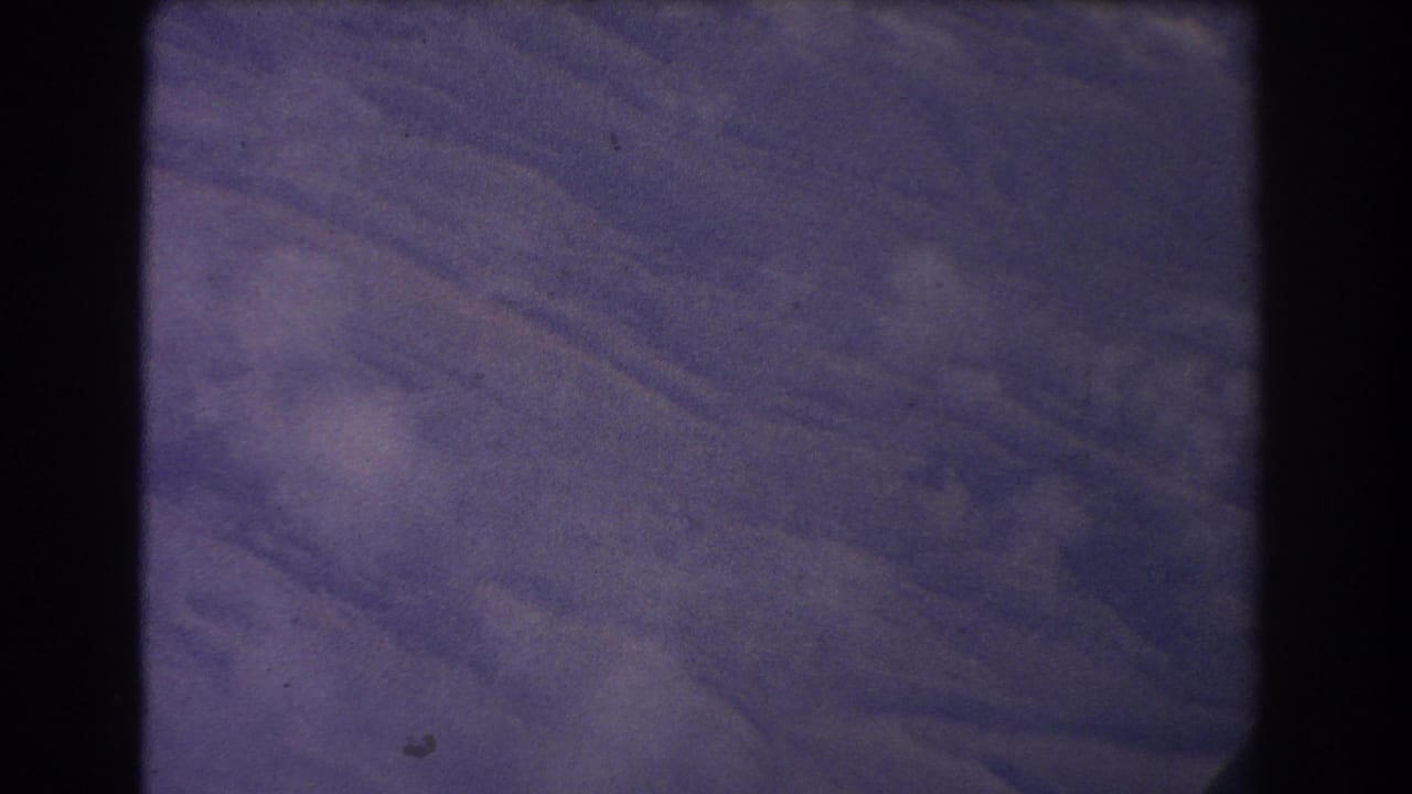 Purple textured surface seen through a dark 8mm film frame border.