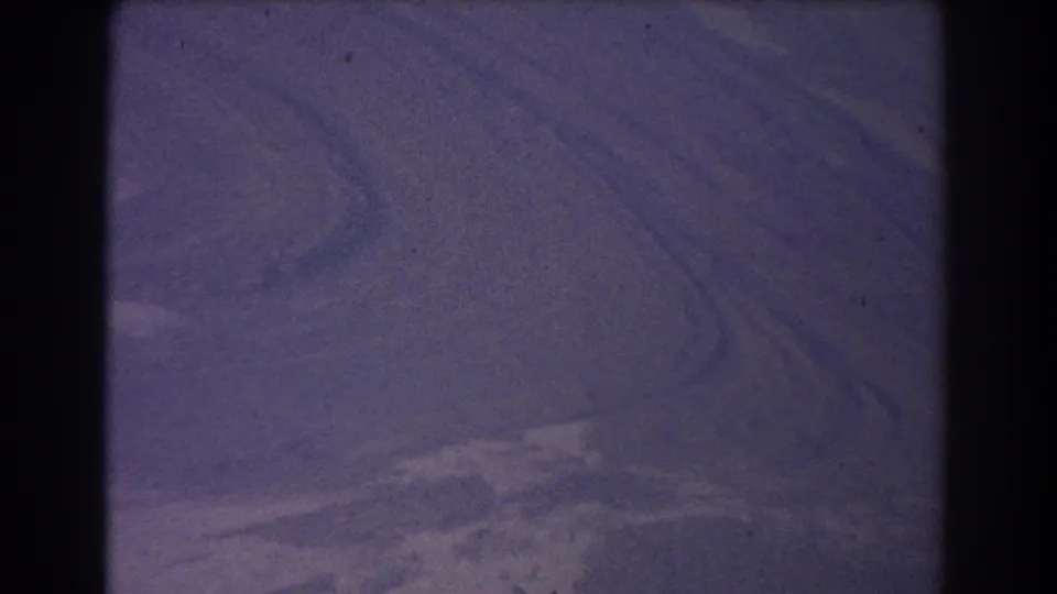 1967 8mm aerial view near the Sydney, Australia metadata location, with abstract landforms and soft aged-film color.