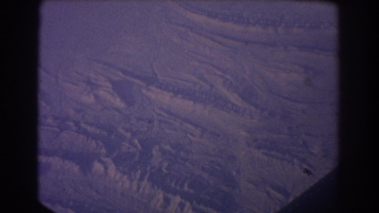 Overhead snowy landscape with ridges and a dark lower corner.
