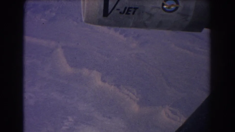Aerial 8mm frame from 1967 showing hazy mountain landscape near Sydney with aircraft structure and V-JET lettering visible.