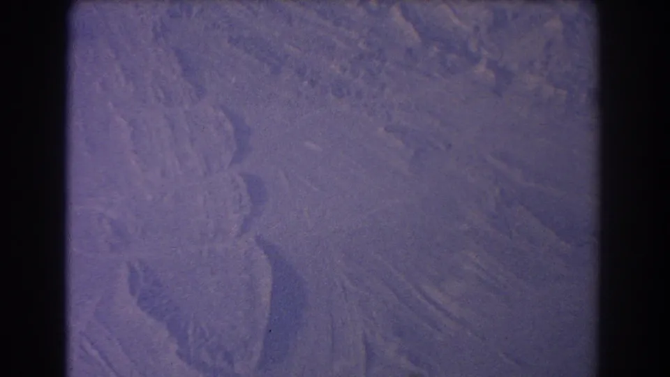 8mm home-movie frame from 1967 showing a passenger view over dry Australian terrain with curved channel-like forms.