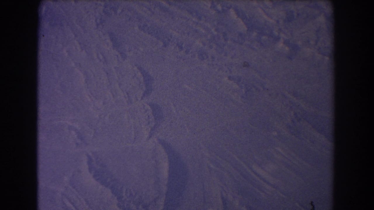 Snow-covered terrain seen from above with dark 8mm frame borders.