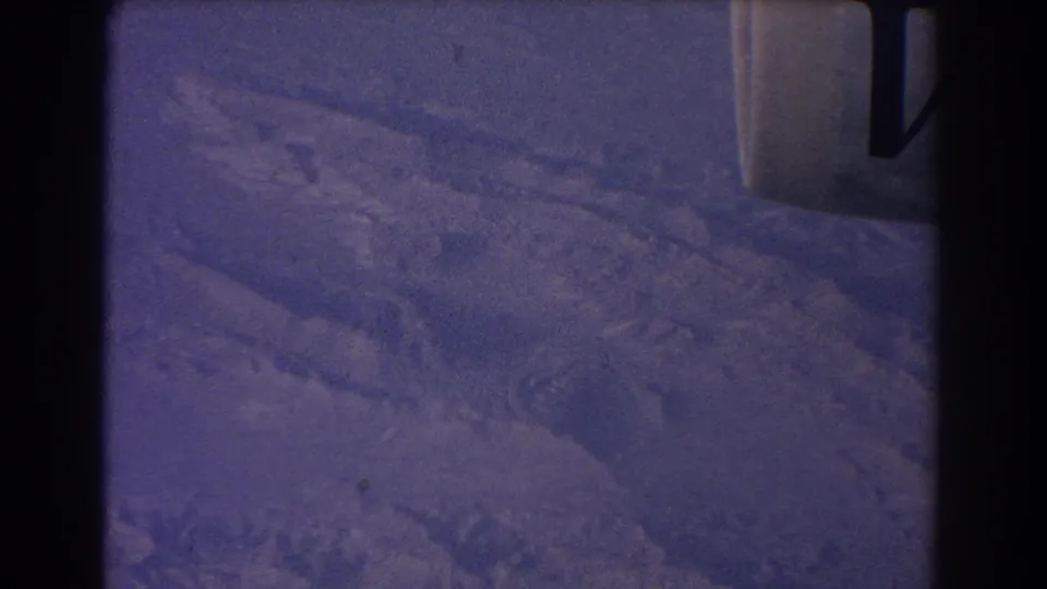 Cataloged 1967 aerial frame with snow-covered terrain below and part of the aircraft or window structure visible at the right edge.