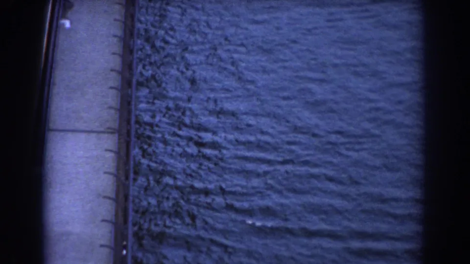 Final 1967 Sydney frame holds on the bridge edge and textured water as the small sailboat passes out of sight.