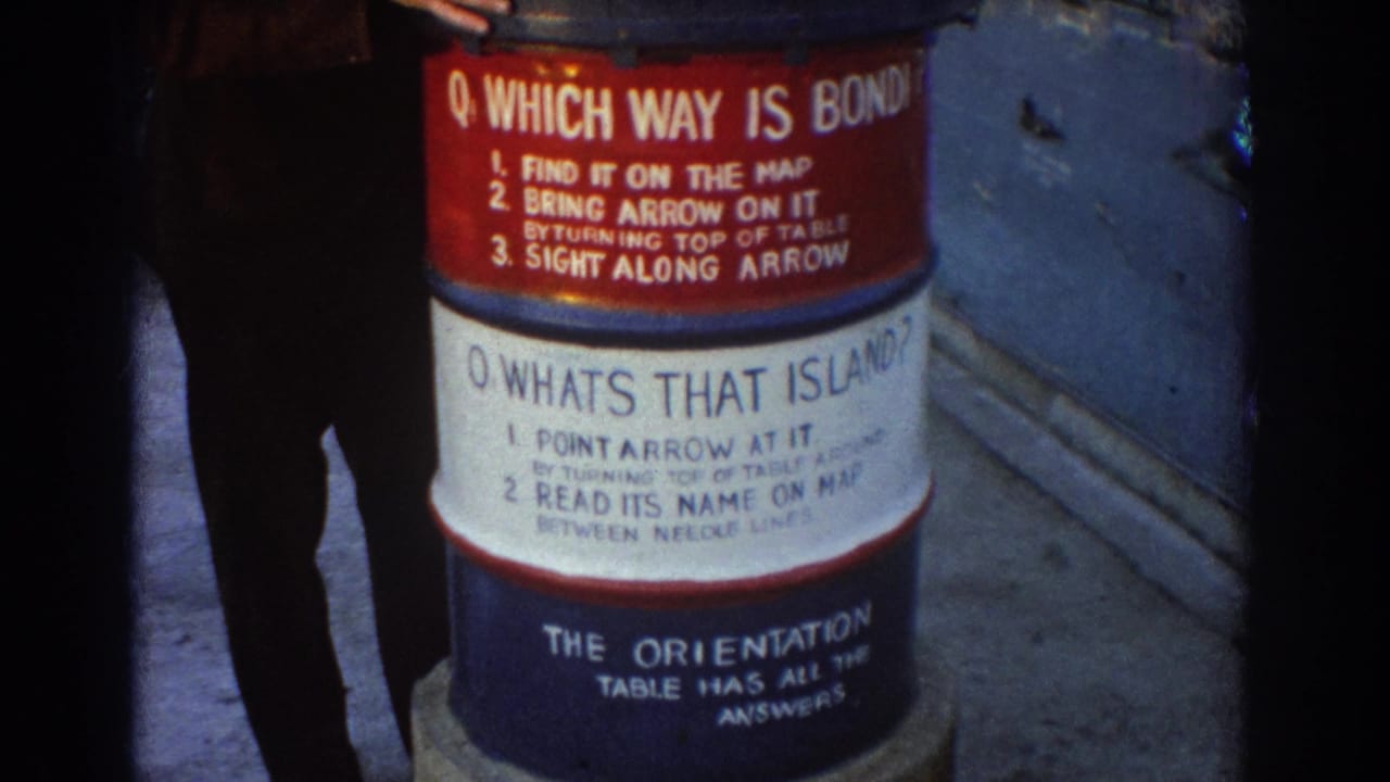 Public orientation sign on a barrel with a partial adult figure standing nearby.