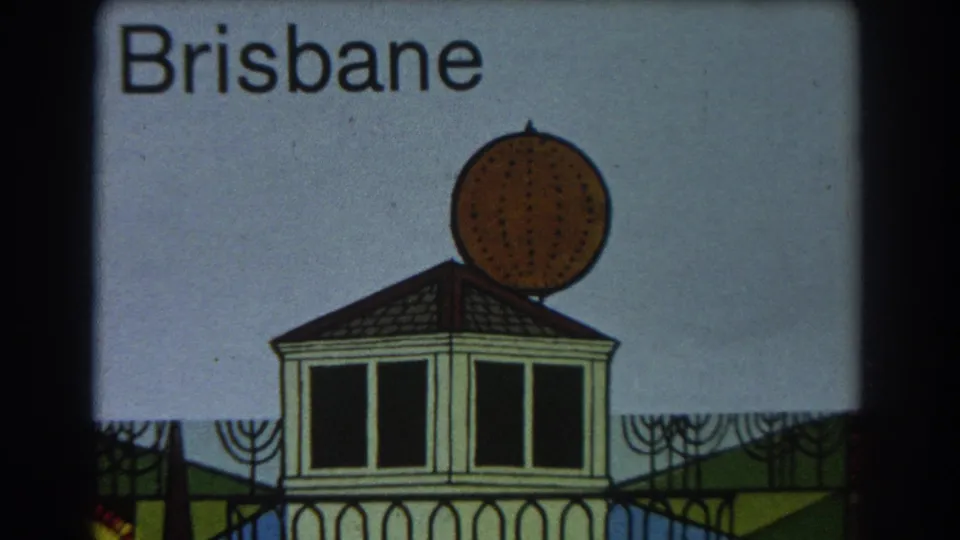 1967 8mm frame of a Brisbane illustrated title card with a stylized building, spherical roof ornament, and pale sky background.