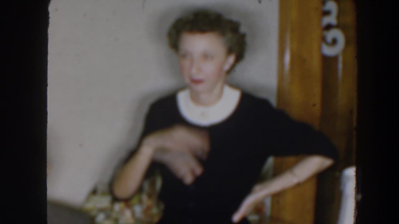 Woman gestures with one hand while facing someone off camera.