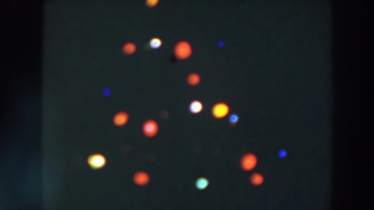 Soft colored lights against a dark background.