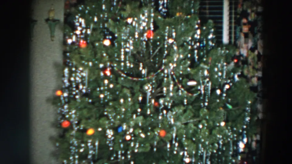A final 1957 Wheeling, Ohio frame shows the Christmas tree with lights, ornaments, and reflective tinsel in a private interior.