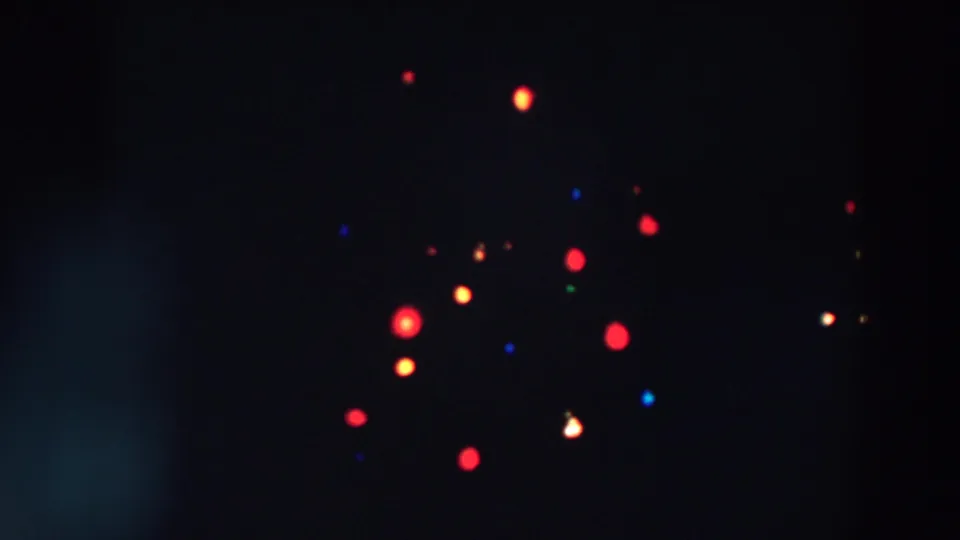 Dark close-up from the 1957 Wheeling, Ohio clip showing scattered colored Christmas bulbs and faint tree branches.