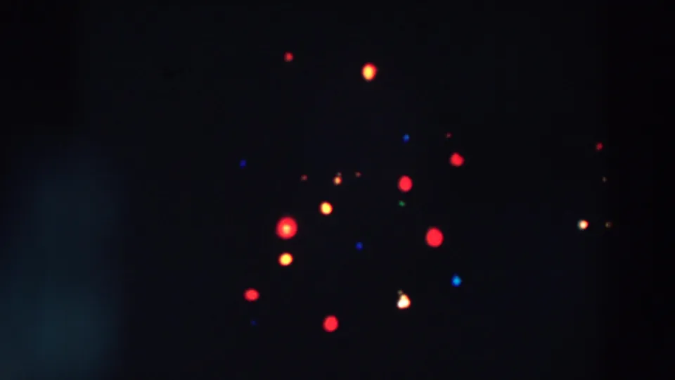 1957 Wheeling, Ohio 8mm frame with soft red, yellow, blue, and green lights scattered across a dark night scene.