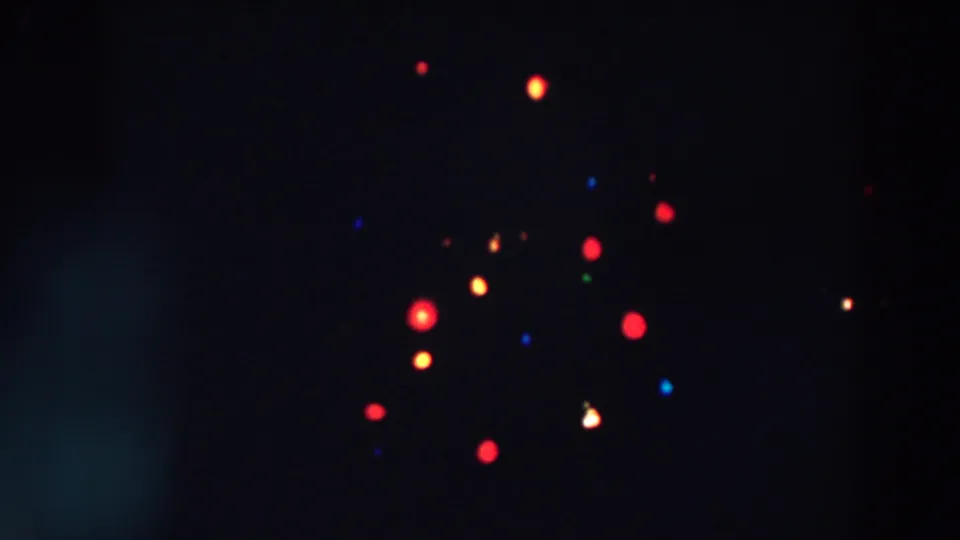 1957 Wheeling, Ohio home-movie frame with softly blurred colored Christmas lights clustered across a dark tree area.