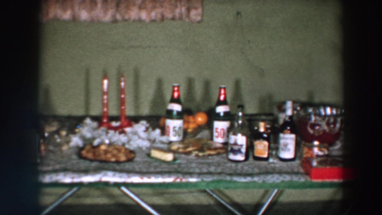 Holiday table with red candles, liquor bottles, food, punch bowl, and bottles marked 50.