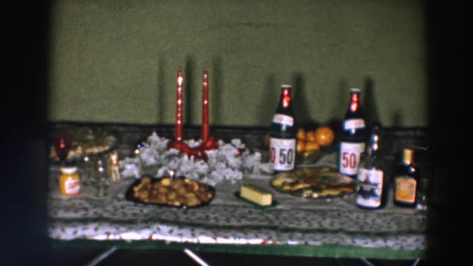 Wheeling, Ohio 1957 home-movie view of a Christmas tabletop arranged with candles, snacks, beer, liquor, fruit, and punch bowl.